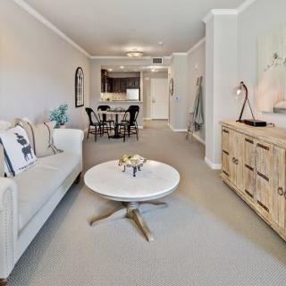 A modern living room with a cozy sofa, stylish coffee table, and adjoining dining area.