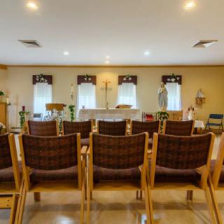 An interior view of a meeting room with arranged chairs facing forward.