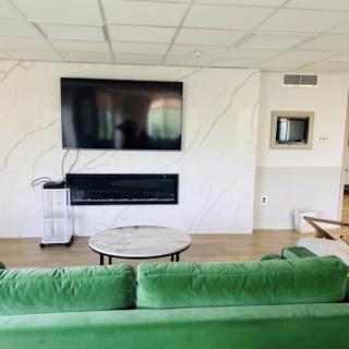 A modern living room featuring a green sofa, a television mounted on the wall, and a stylish coffee table.