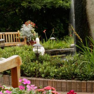 A serene garden with benches, colorful flowers, and a tranquil fountain.