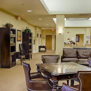 A warm and inviting lobby with comfortable seating, bookshelves, and a reception area.