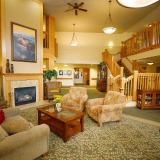 A cozy living room with comfortable seating, a fireplace, and an elegant staircase.