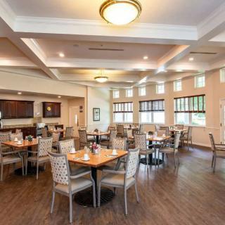 A spacious and elegantly decorated dining room with multiple tables and chairs.