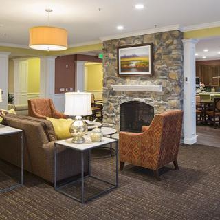 A cozy living room with comfortable seating, a stone fireplace, and warm lighting.