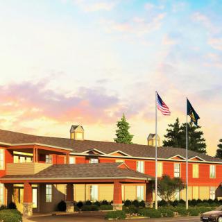 A hotel with flags flying at sunset.