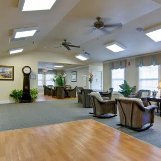 A spacious, brightly lit living area with comfortable seating and indoor plants.