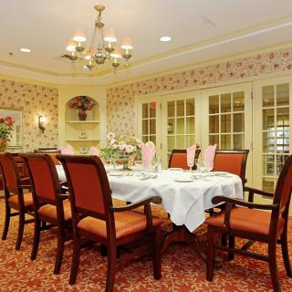 An elegantly decorated dining room with a set table and classic furnishings.
