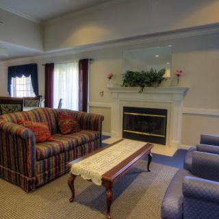 A cozy living room featuring a striped sofa, fireplace, and coffee table with elegant decor.