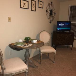 Cozy dining nook with a small table and two chairs next to a TV.