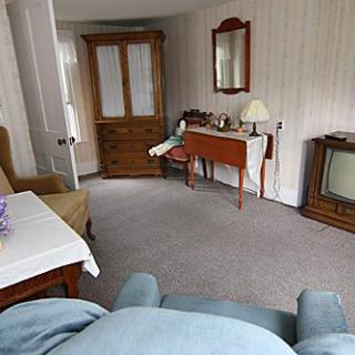 A cozy vintage living room with wooden furniture and an old television.