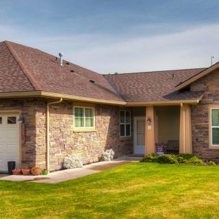 A suburban house with a well-maintained lawn and brick exterior.