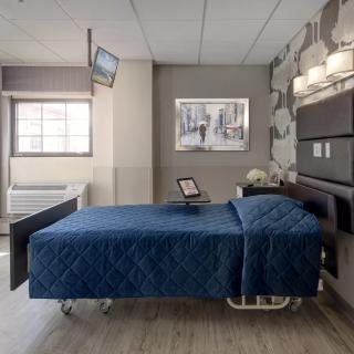 A modern hospital room with a single bed and contemporary decor.