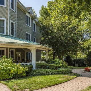 A charming residential house with a well-maintained garden and pathway.