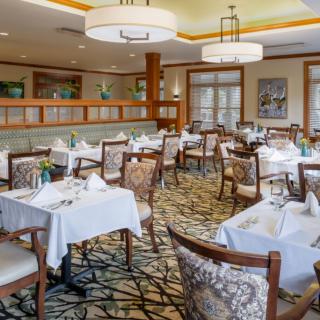 An elegant restaurant dining room with neatly arranged tables and chairs.