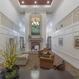 A spacious living room with high ceilings, featuring a fireplace and elegant decor.