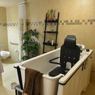 A serene bathroom featuring a comfortable bathtub, plants for decoration, and a simple yet elegant design.