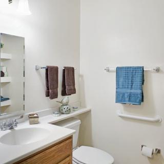 A neatly organized bathroom with towels, a sink, and a mirror.