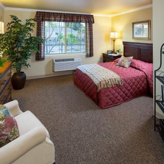 Cozy bedroom with a bed, armchair, and decorative elements.