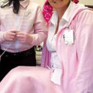 Two individuals in a medical setting wearing pink clothing.