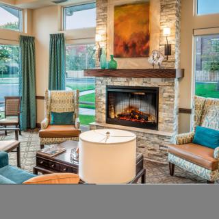 A cozy living room featuring a stone fireplace and comfortable seating arrangements.