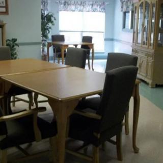 A dining area with a wooden table and chairs in a bright room.