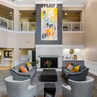A modern living room with sleek furniture, a central fireplace, and vibrant artwork.