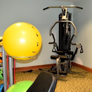 A gym room featuring a multi-gym machine and a yellow stability ball.