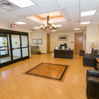 A spacious and well-lit lobby with a reception desk and comfortable seating.