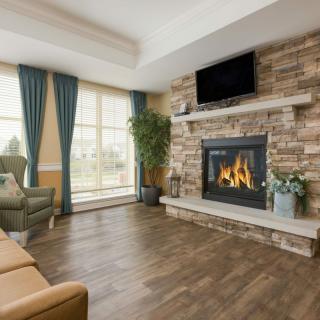 A cozy living room with a stone fireplace and wooden flooring.