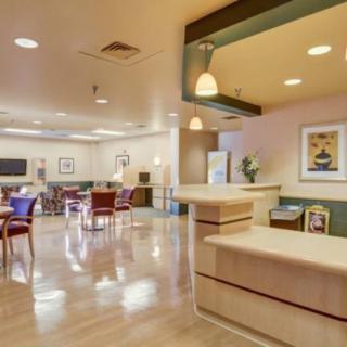 A well-lit lobby with a seating area and a reception desk.