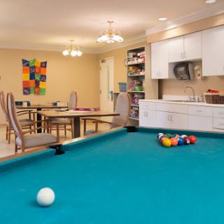 A spacious game room featuring a pool table and a cozy dining area, designed for relaxation and entertainment.