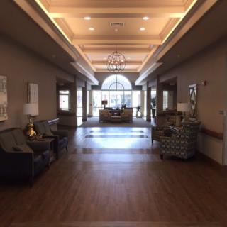 A spacious and elegantly decorated lobby with ample lighting and stylish furniture.