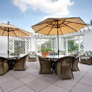 A stylish outdoor patio with tables and chairs under large umbrellas.