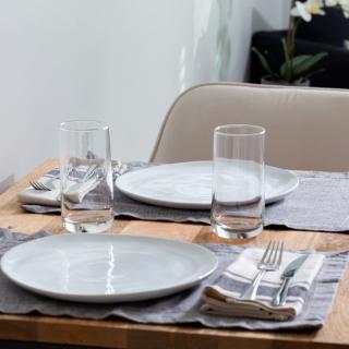 A neatly set dining table with plates, glasses, and cutlery.