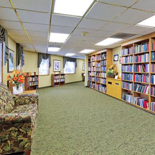 A cozy library with bookshelves lining the walls and comfortable seating.