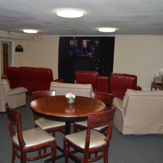 A cozy living room with sofas, a round table, and chairs.