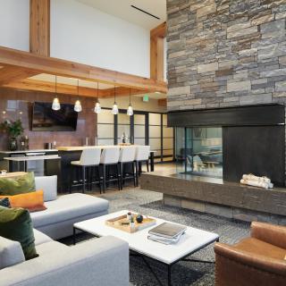 A modern living room with a stone fireplace and open floor plan.