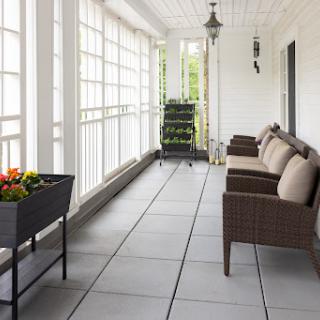 A beautifully designed porch featuring comfortable seating and potted plants.