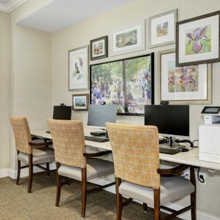 A well-organized office space with multiple workstations and decorative artwork on the walls.