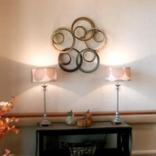 A stylish interior setup featuring wall art and illuminated lamps on a console table.