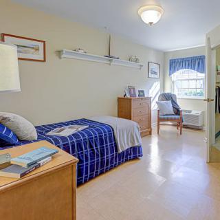 A cozy, well-lit bedroom with a single bed and nautical-themed decor.