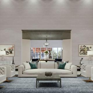 A modern living room with neutral tones, featuring comfortable sofas and a central coffee table under soft indoor lighting.