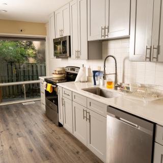 Modern kitchen with white cabinets and stainless steel appliances.