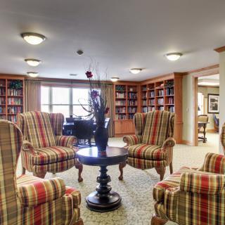 A cozy library space with armchairs and bookshelves.