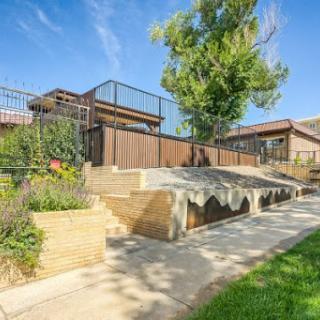 A beautifully landscaped backyard featuring a well-maintained pathway, steps leading to an upper level, and greenery surrounding the area.