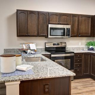 A modern kitchen with granite countertops and stainless steel appliances.