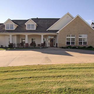 A suburban house with a spacious driveway and front porch.