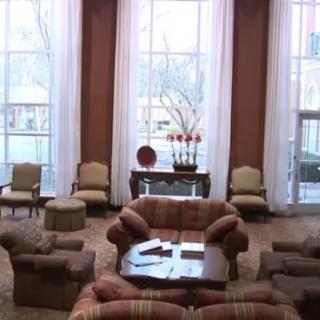 A cozy lobby seating area with large windows and comfortable furniture.