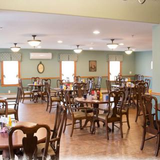 An empty dining room with neatly arranged tables and chairs.