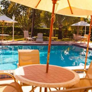 A sunny day by the outdoor pool with chairs and umbrellas set up for relaxation.
